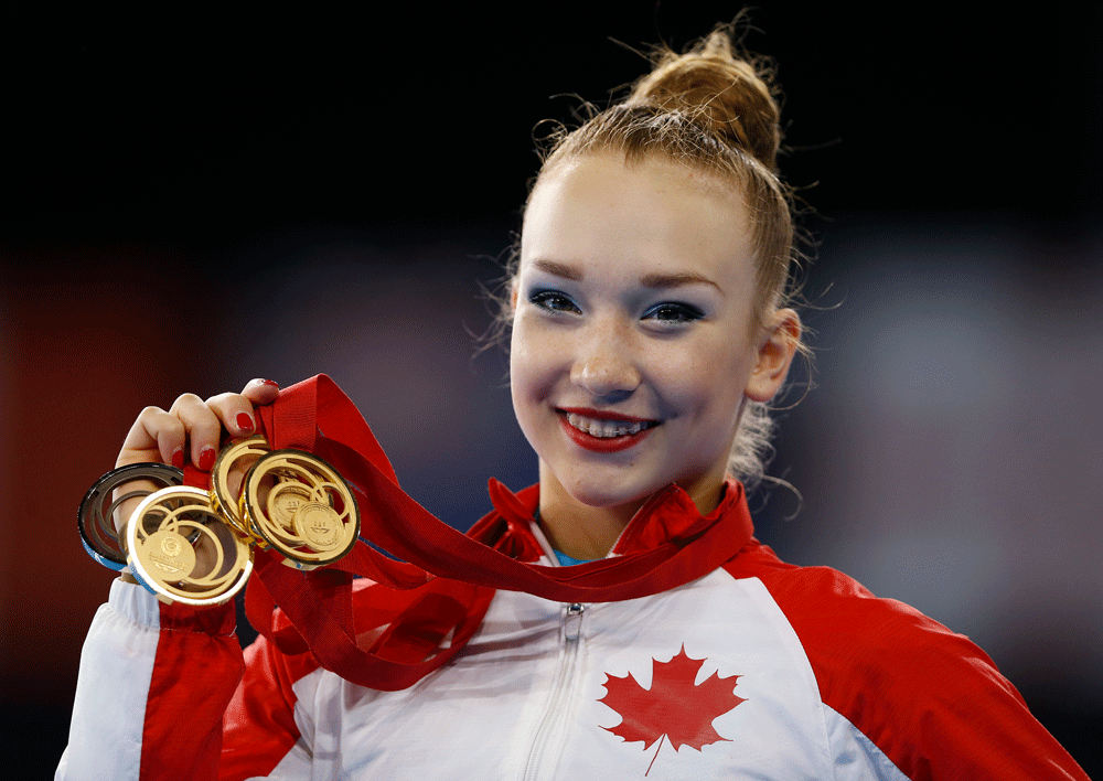 Patricia Bezzoubenko of Canada holds up her three gold and one bronze medals after the Rhythmic Gymnastics Individual finals at the Scottish Exhibition and Conference Centre Precinct during the Commonwealth Games 2014 in Glasgow, Scotland, Saturday July 26, 2014. (AP Photo