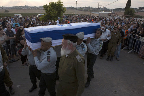 Israeli soldiers carry the flag-draped coffin of their comrade Barak Refael Degorker, who died after suffering wounds from Gaza mortar fire, during his funeral in Gan Yavne, near Ashdod July 27, 2014. Fighting subsided in Gaza on Sunday after Hamas Islamist militants said they backed a 24-hour humanitarian truce, but there was no sign of any comprehensive deal to end their conflict with Israel. Some firing of rockets continued after the time that Hamas had announced it would put its guns aside and Israeli Prime Minister Benjamin Netanyahu questioned the validity of the truce. REUTERS