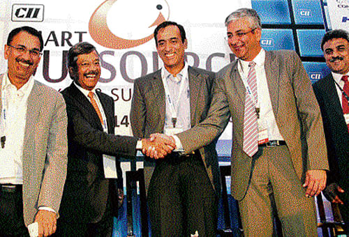 Genpact Vice-Chairman Pramod Bhasin shakes hands with CII Karnataka Chairman and Maini Precision Products Director Sandeep K Maini at the inauguration of Outsource Expo and Summit organised by CII in Bangalore on Tuesday.