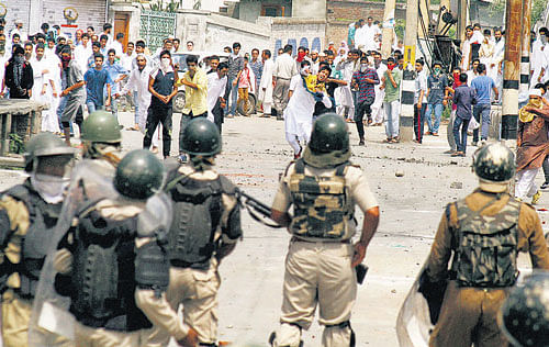 Youth throwing stones at security forces during  a clash on Tuesday. PTI