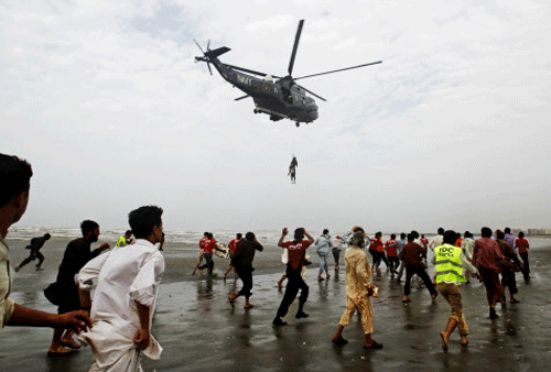 A Pakistan Navy helicopter evacuates a recovered body of a victim who drowned over Clifton beach in Karachi, Pakistan, Thursday, July 31, 2014. Scores of people drowned despite a ban on entering and bathing in the sea due to high tides, after thousands of people turned up on various beaches of Karachi to celebrate Muslims festive day of Eid. (AP Photo)