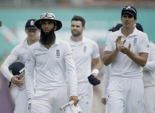 England spinner Moeen Ali, center left, walks off holding a stump after taking six wickets beside his captain Alastair Cook, right, after defeating India on the fifth and final day of the third cricket test match of the series between England and India at The Ageas Bowl in Southampton, England, Thursday, July 31, 2014. AP photo
