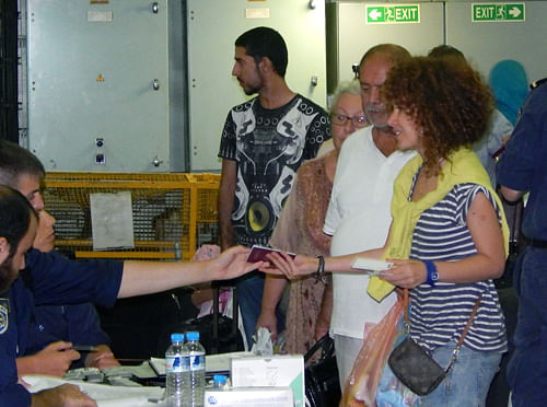 In this handout photo provided by the Hellenic Navy, evacuees submit their passports for inspection after boarding the Greek frigate Salamis, anchored outside Libya's capital Tripoli , Early Friday, Aug. 1, 2014.  AP Photo
