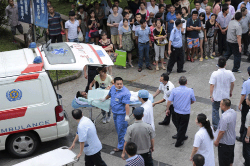 Medical personnel transport a victim (C) at a hospital after an explosion at a factory in Kunshan, Jiangsu province August 2, 2014.  Reuters photo