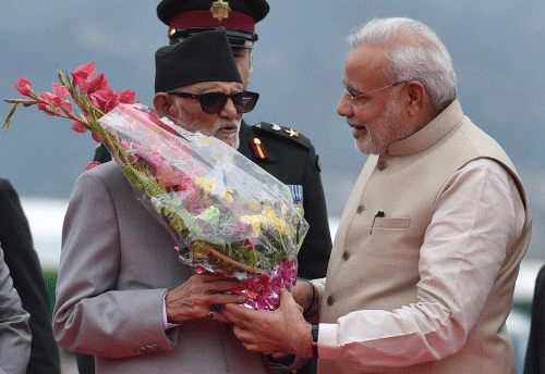 Prime Minister Narendra Modi being welcomed by his Nepalese counterpart Sushil Koirala on arrival at Tribhuvan International Airport in Kathmandu, Nepal on Sunday. PTI Photo