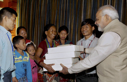 me Minister Narendra Modi giving presents to the family of Jeet Bahadur (2R) in Kathmandu, Nepal on Sunday. The young boy has been raised by the PM in Gujarat. PTI photo