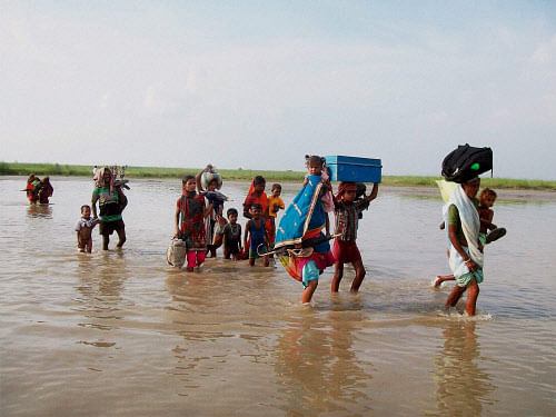Villagers moving to safer places due to the danger to Kosi's embankments after heavy flow of water into the river from Nepal's side in Supaul. PTI photo