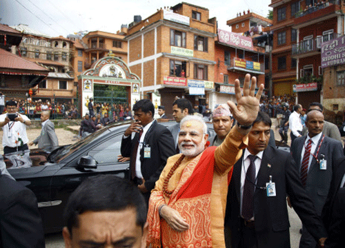 Prime Minister Narendra Modi waves at supporters waiting to greet him at the premises of Pashupatinath Temple in Kathmandu August 4, 2014. Reuters photo