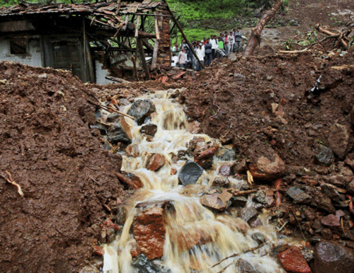 Villagers watch a rescue operation standing by mud and slush at the site of a landslide in Malin village in Pune district. PTI photo