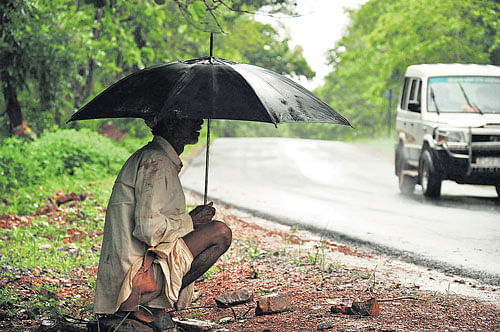 A man seen on the roadside during rain on the outskirts of Dharwad.  DH photos
