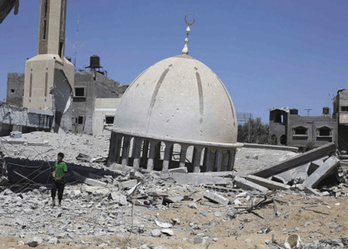 A Palestinian boy stands next to the remains of a mosque in Khuzaa town, which witnesses said was heavily hit by Israeli shelling and air strikes during Israeli offensive, in the east of Khan Younis in the southern Gaza Strip. Reuters photo