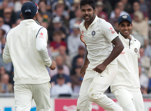 Indias Varun Aaron, centre, celebrates after taking the wicket of Englands Moeen Ali for 13 on the second day of the fourth test match of their five match series at Old Trafford cricket ground, in Manchester, England, Friday, Aug. 8, 2014. AP Photo
