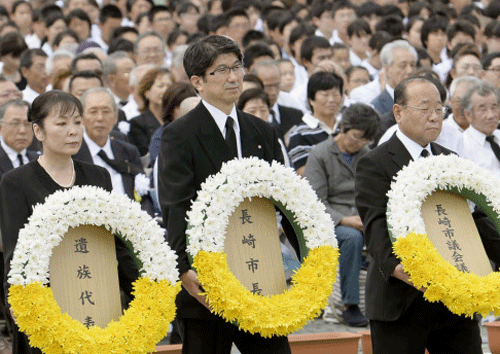 Nagasaki Mayor Tomihisa Taue, center, carries a wreath of flowers during a ceremony at Nagasaki Peace Park in Nagasaki, southern Japan Saturday, Aug. 9, 2014 to mark the 69th anniversary of the atomic bombing. AP photo
