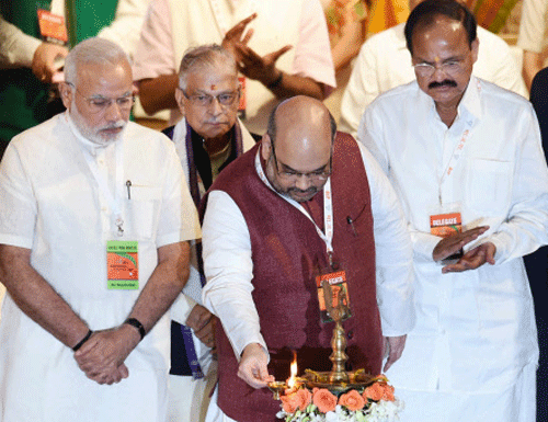 BJP President Amit Shah lights the lamp as Prime Minister Narendra Modi and senior leaders M M Joshi and M Venkaiah Naidu look on during the party's National Council meet in New Delhi on Saturday. PTI Photo