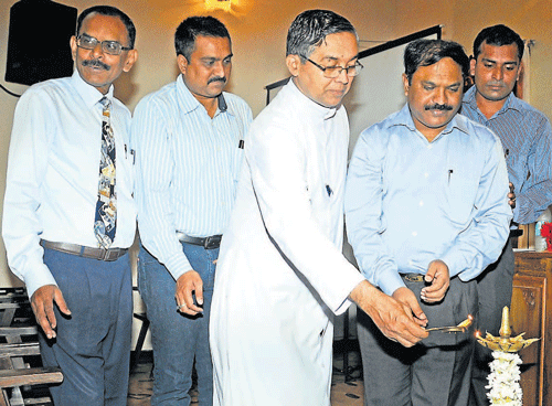 Director of State Directorate of Minorities, Akram Pasha, along with Milagres church Parish Priest Fr Valerian D'Souza lighting the lamp at the Christian development awareness programme in Mangalore on Saturday. DH PHOTO