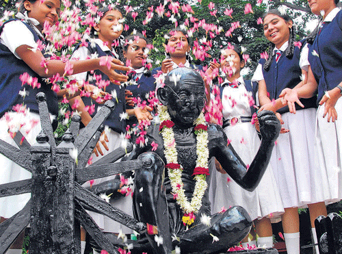 Students pay floral tributes to a statue of Mahatma Gandhi on the 64th anniversary of Quit IndiaMovement at Pratibha Bala Mandira in Bangalore on Saturday. DH PHOTO