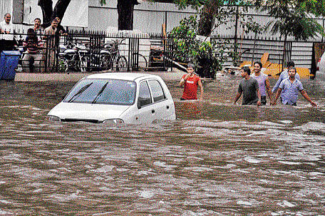 A vehicle moves through a street that was waterlogged following heavy rain in Jaipur on Saturday. PTI