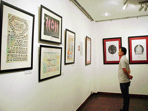 A visitor looks at the Buddhist Bhoti and Islamic  calligraphy work put on display.