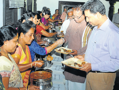 Deputy Commissioner A B Ibrahim and Hampi Kannada University former vice chancellor Prof B A Viveka Rai among others taste the Aati delicacies in Pilikula on Tuesday. DH PHOTOS