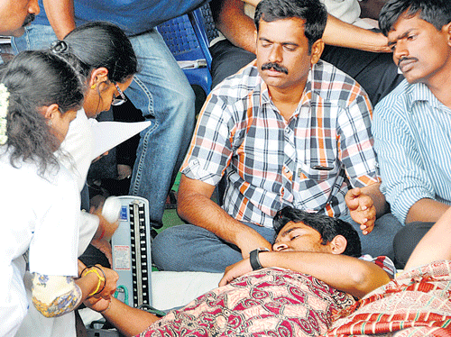 Doctors attend to a KPSC candidate after he fell ill while staging a protest at the FreedomPark in Bangalore on Tuesday. DH PHOTO