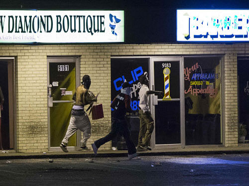 Vandals attacked stores in Ferguson early today, hours after police said the unarmed black teenager whose killing by a white officer unleashed days of rioting was a robbery suspect. Reuters photo