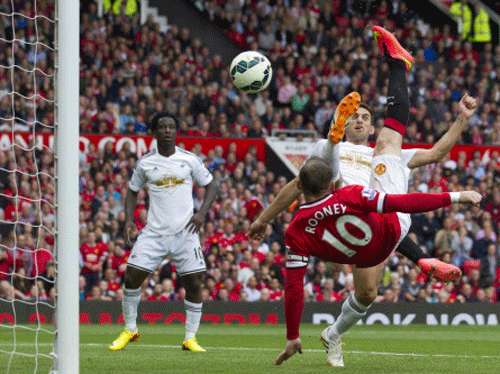 Manchester United's Wayne Rooney, right, scores against Swansea City during their English Premier League soccer match at Old Trafford Stadium, Manchester, England, Saturday Aug. 16, 2014. AP Photo