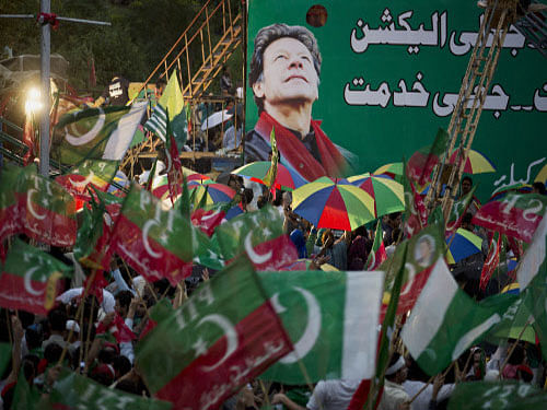 Supporters of Pakistan's cricketer-turned-politician Imran Khan wave their party flags at a rally in Islamabad, Pakistan. Pakistan opposition leader Imran Khan today warned the PML-N government that thousands of his supporters could enter the high-security Red Zone here if Prime Minister Nawaz Sharif refuses to quit, as popular cleric Tahir-ul Qadri issued a 48-hour ultimatum demanding the same. AP photo