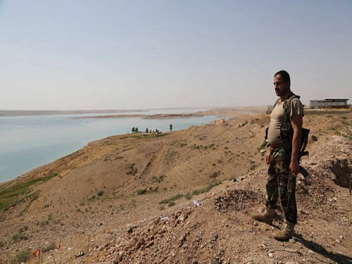 A Kurdish peshmerga fighter stands guard near the Mosul Dam at the town of Chamibarakat outside Mosul, Iraq. Kurdish forces took over parts of the largest dam in Iraq on Sunday less than two weeks after it was captured by the Islamic State extremist group. AP photo