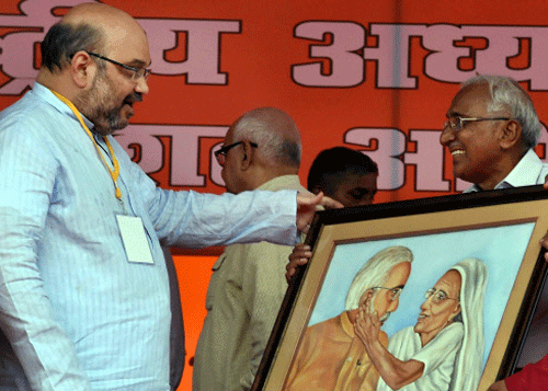 BJP National President Amit Shah is presented with a painting of Prime Minister Narendra Modi and his mother during a party workers' meeting in Lucknow on Tuesday. PTI Photo