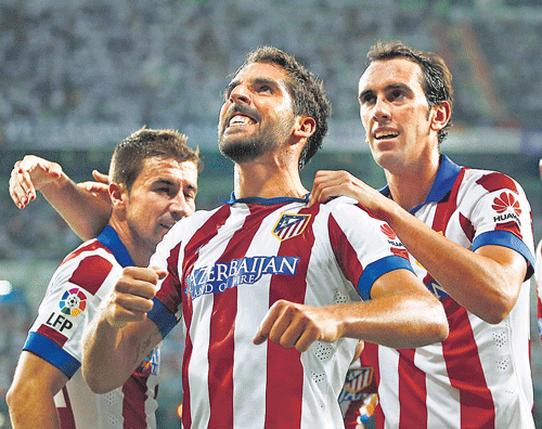 vital strike Atletico's Raul Garcia (centre) celebrates with teammates after scoring in their Spanish Super Cup match against Real Madrid at the Santiago Bernabeu on Tuesday. AP