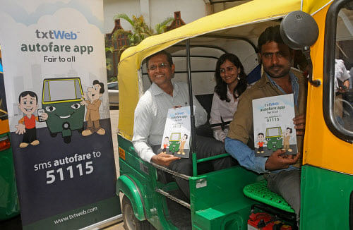 Additional Commissioner of Police (Traffic) B Dayananda and txtWeb Business Head Srividhya Ramarathnam ride an auto during the launch of Autofare app in the City on Thursday.  DH photo