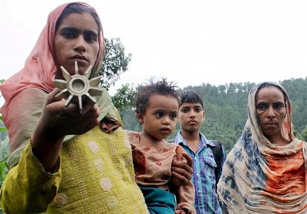 In this file photo, residents show an unexploded rocket at a village along the LoC in Poonch. PTI