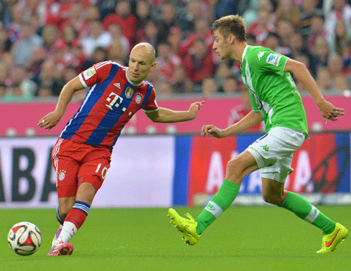 Bayerns Arjen Robben from the Netherlands, left, and Wolfsburgs Robin Knoche challenge for the ball during the soccer match between FC Bayern Munich and VfL Wolfsburg in the Allianz Arena in Munich, Germany, on Friday, Aug. 22, 2014. AP photo