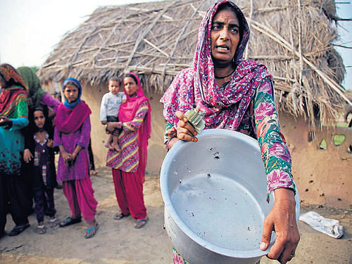 A village woman displays a vessel damaged by gunfire allegedly from the Pakistan side at Jora Farm village in the Ranbir Singh Pura region of the India-Pakistan border, about 35 km from Jammu, on Saturday. AP