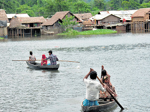 Villagers shift to safer areas by boats from flood-hit Kaziranga, Assam, on Saturday.  PTI