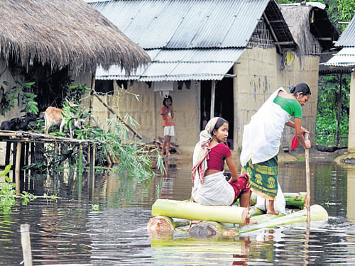 Women paddle through their village to a safer place after more than 19 villages were flooded, forcing people to evacuate their houses in Dibrugarh on Sunday.   PTI