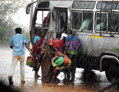 Passengers board a bus in heavy rain in Bagaklot.