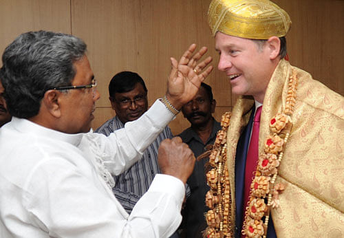 Chief Minister Siddaramaiah greets Deputy Prime Minister of the United Kingdom, Nick Clegg, with a Mysore peta at the Vidhana Soudha in Bangalore on Wednesday. DH PHOTO