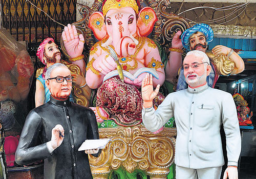 VIP&#8200;LORD: Statues of President Pranab Mukherjee and Prime Minister Narendra Modi flank an idol of Lord Ganesha at a shop on R V Road, on the eve of Ganesha Chaturthi, on Friday. DH photo