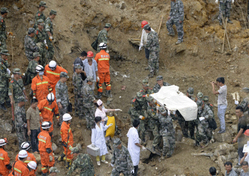 Rescuers carry a body of a victim as they walk among debris at the site of a landslide, under heavy rainfall in Yingping village of Fuquan, Guizhou province. Reuters photo