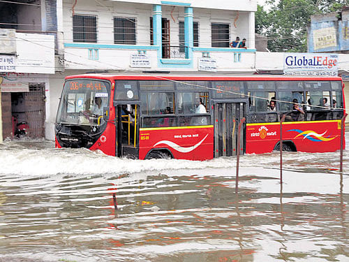 Abus passes through a flooded street after heavy rain in Gulbarga on Saturday. KPN
