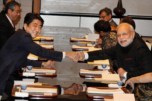 Prime Minister Narendra Modi shakes hands with his Japanese counterpart Shinzo Abe during a dinner at State Guest House in Kyoto on Saturday. PTI Photo