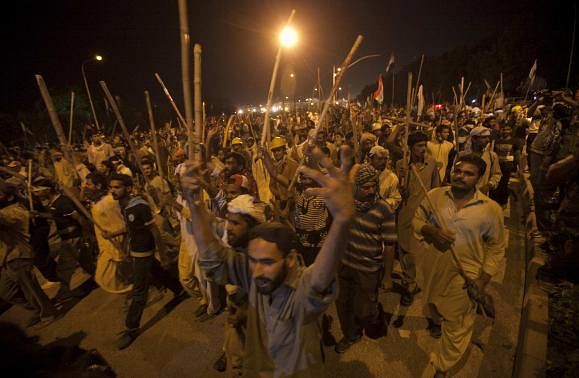 Supporters of Tahir ul-Qadri, Sufi cleric and leader of political party Pakistan Awami Tehreek (PAT), carry sticks as they move towards the Prime Minister's house during the Revolution March in Islamabad August 30, 2014. REUTERS-Akhtar Soomro