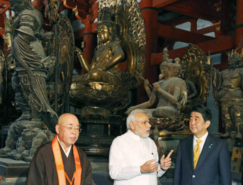 India's Prime Minister Narendra Modi (C) talks with Japanese counterpart Shinzo Abe (R) in front of Buddha statues as they visit Toji Buddhist temple, a UNESCO World Heritage site, in Kyoto, western Japan, in this photo released by Kyodo August 31, 2014. Reuters photo
