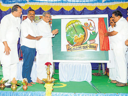 District-in-Charge Minister B Ramanath Rai unveils the logo of Vishwa Tuluvere Parba at a programme held at the premises of Mangalore Taluk Mahila Mandala Okkoota building in Urva Store on Sunday. Dharmasthala Dharmadhikari D Veerendra Heggade, Minister for Health and Family Welfare U T Khader, MLC Ivan DSouza, artiste John Chandran and others look on. DH PHOTO