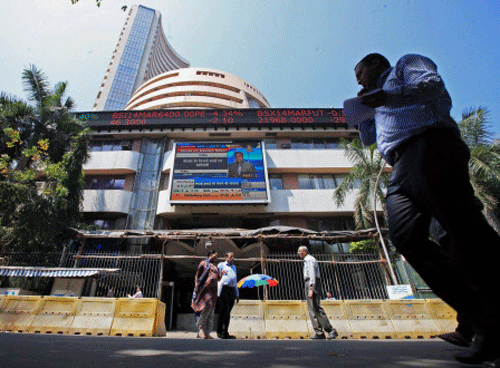 People walk past the BSE during intra-day trading at a brokerage house in Mumbai. PTI file photo