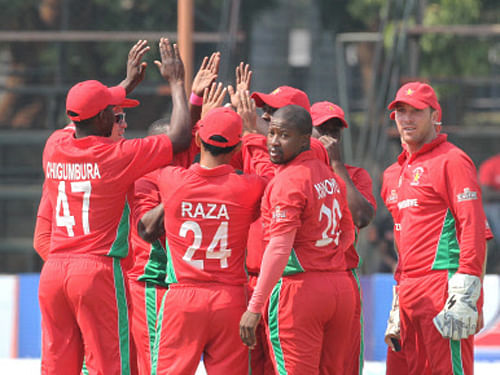 Zimbabwean players celebrate the wicket of Australian batsman Phil Hughes during the cricket One Day International match against Australia in Harare, Zimbabwe. AP photo