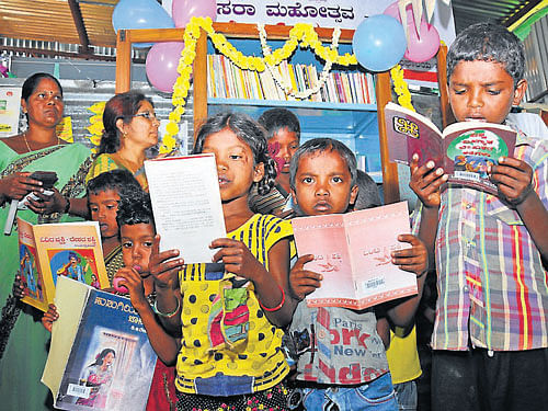 Children of Mahouts and Kavadis read books during the inauguration of the Tent Library at the Palace premises, in Mysore, on Monday. DH PHOTO