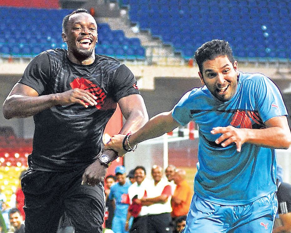 Yuvraj Singh holds off Usain Bolt to win a 100-m race at the end of their friendly match at the Chinnaswamy Stadium in Bangalore on Tuesday. DH PHOTO
