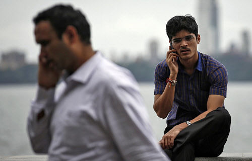 Big brother watching? Men speak on their mobile phones on a seafront in Mumbai. Reuters Reuetrs photo for representation only